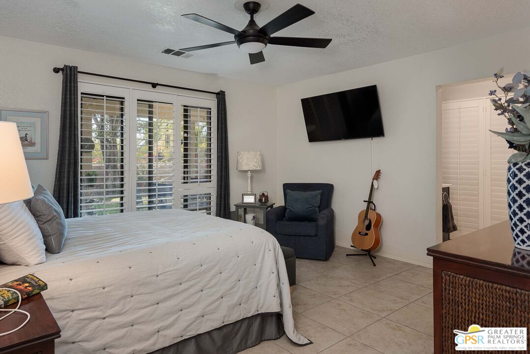 9760 Capiland Road Desert Hot Springs, CA 92240 - Photo 10 of 16 a bedroom with a bed a flat screen tv and a couch