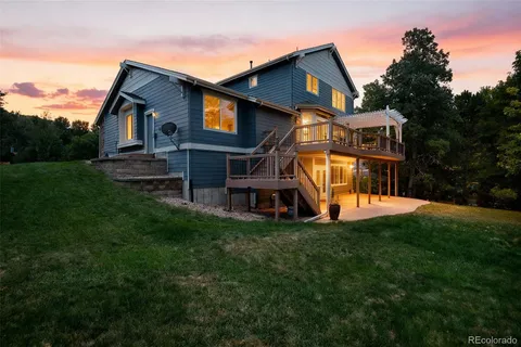 a living room with furniture and three large window