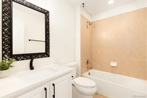 a bathroom with a granite countertop sink a toilet and shower