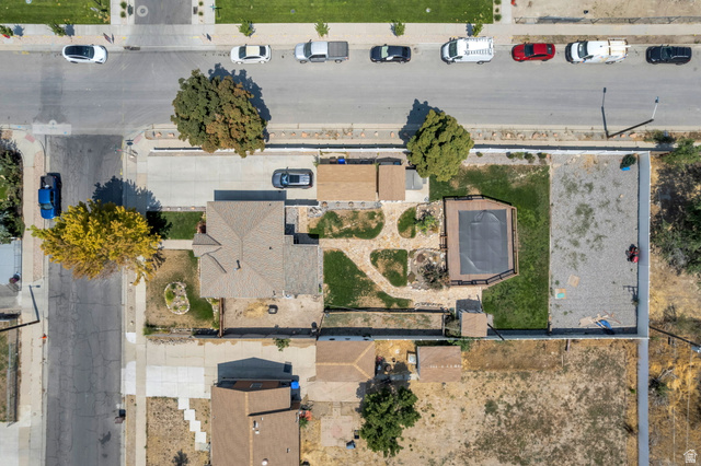 7391 Elm Street Midvale, UT 84047 - Photo 4 of 38 Gable roofline, rear deck with a covered pool, paved driveway, and established trees