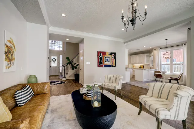 a living room with furniture and a chandelier