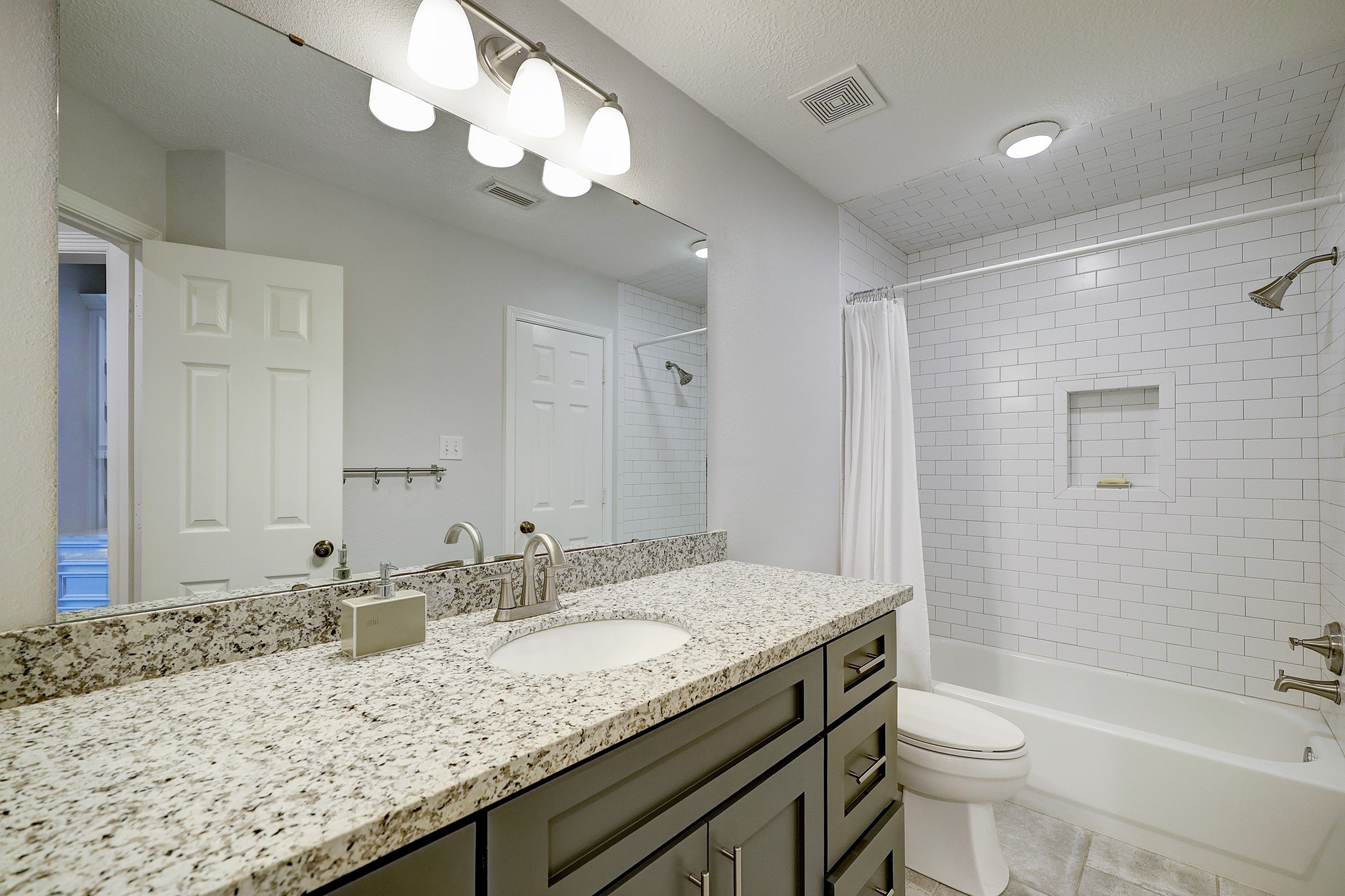 18902 Mountain Spring Drive Spring, TX 77379 - Photo 26 of 32 a bathroom with a granite countertop sink a toilet a mirror a bathtub and shower