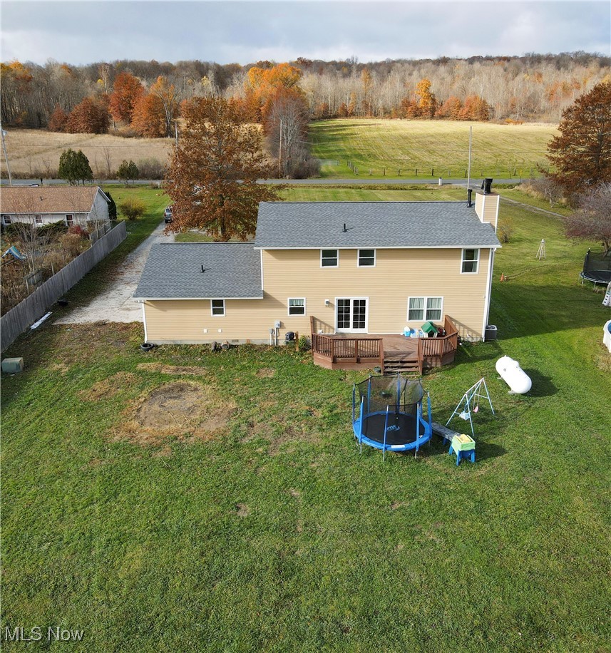 9278 Bryant Road Windham, OH 44288 - Photo 40 of 47 Back of property with a lawn, a trampoline, a deck, a chimney, and a wooded view