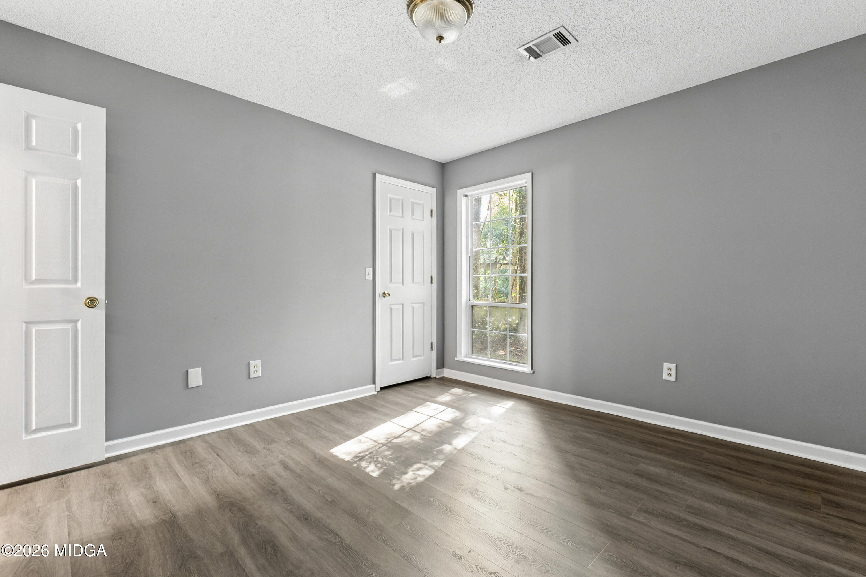 5626 Janeru Circle Macon, GA 31216 - Photo 22 of 45 a view of empty room with wooden floor and fan