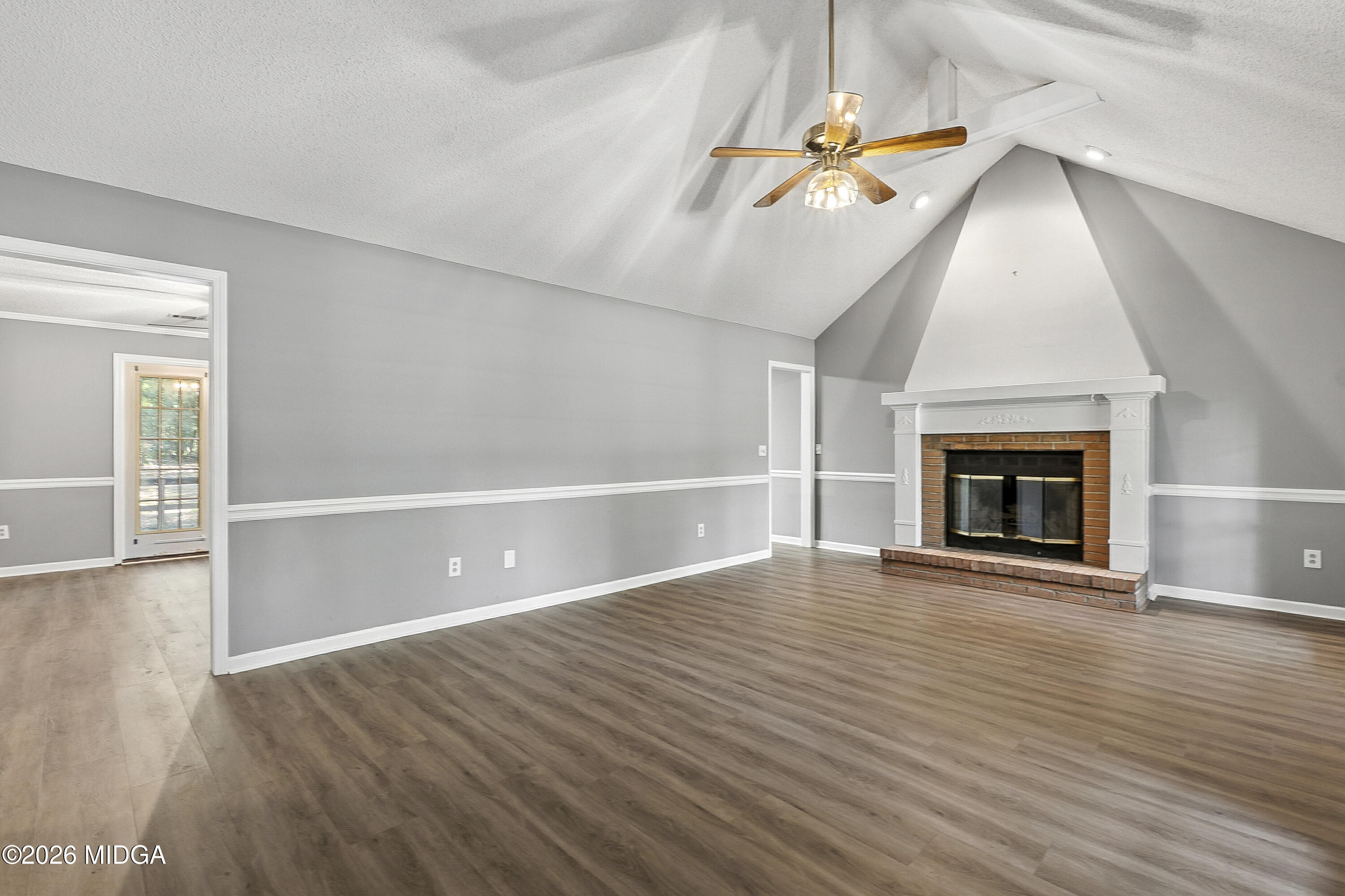 5626 Janeru Circle Macon, GA 31216 - Photo 7 of 45 an empty room with wooden floor fireplace and windows