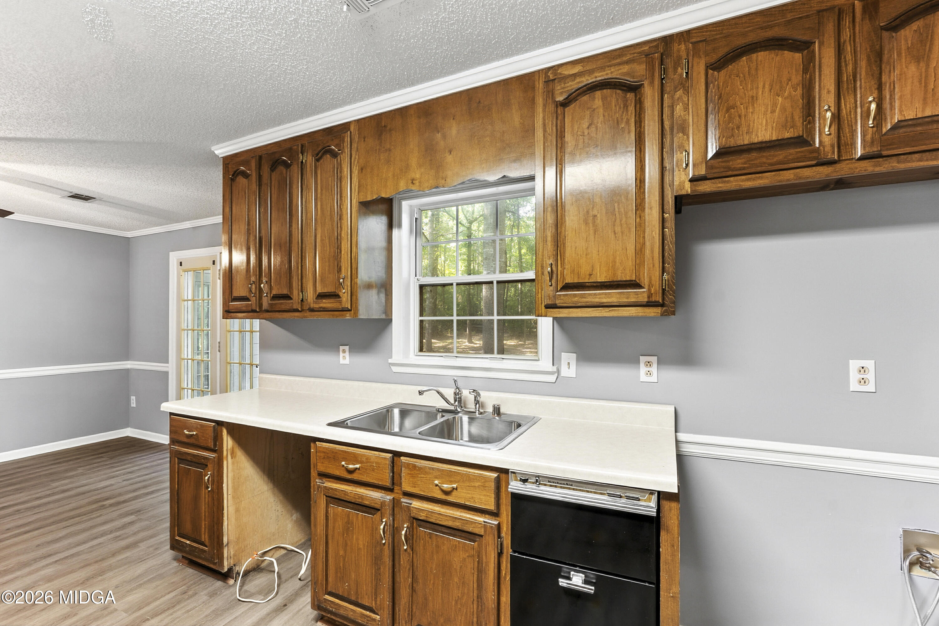 5626 Janeru Circle Macon, GA 31216 - Photo 9 of 45 a kitchen with stainless steel appliances granite countertop a sink dishwasher stove and wooden cabinets with wooden floor