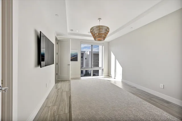 a view of a hallway with an entryway and chandelier