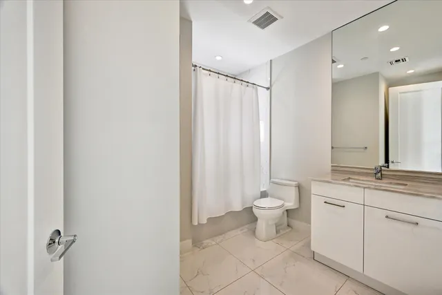 a bathroom with a double vanity sink toilet and a mirror
