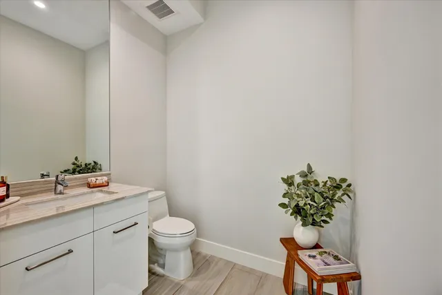 a bathroom with a toilet a sink and mirror