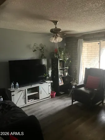 a living room with furniture a flat screen tv and a window