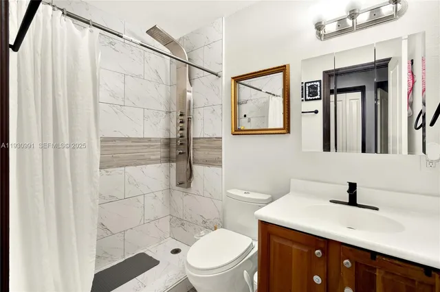 a bathroom with a sink mirror vanity and toilet