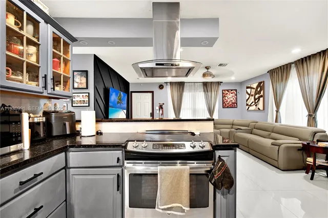 a kitchen with stainless steel appliances granite countertop a sink stove and refrigerator