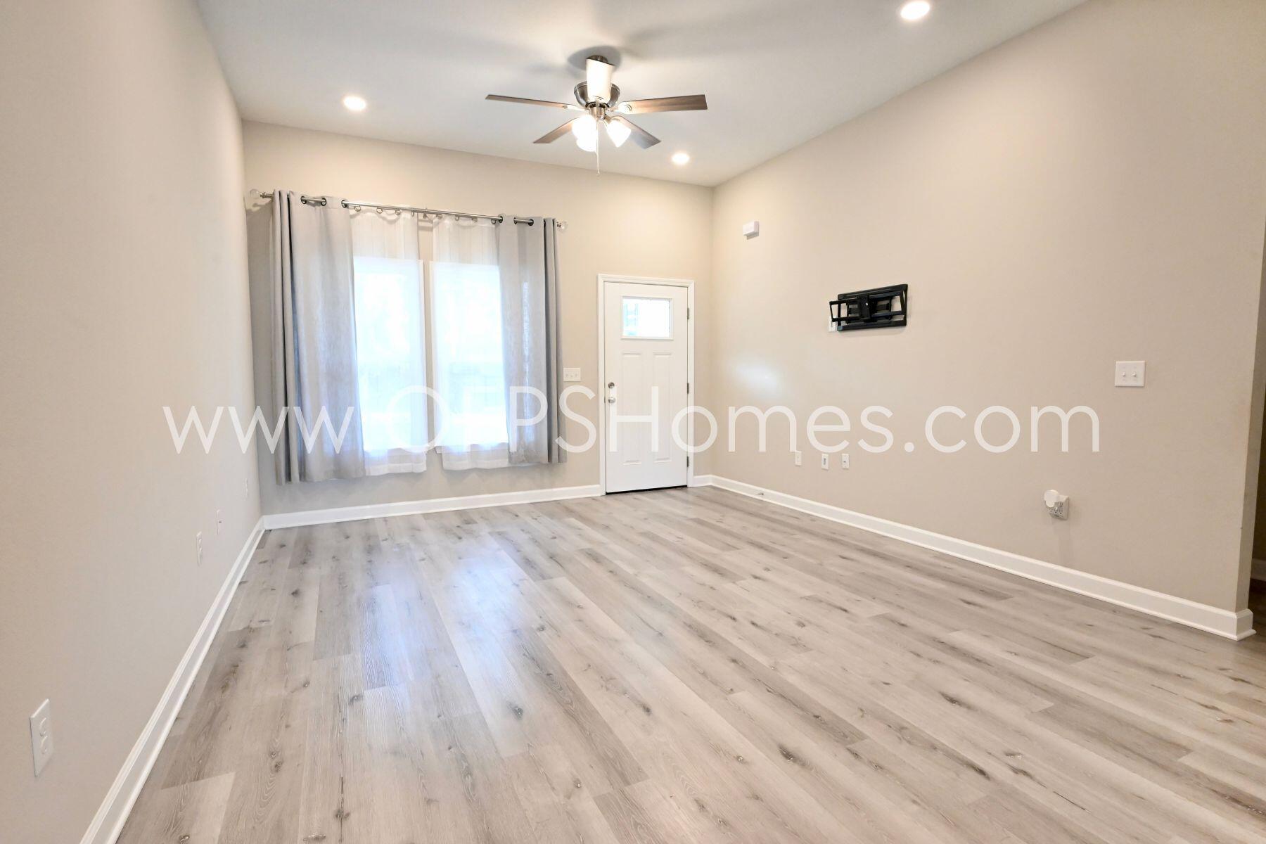 113 Shady Lane Crestview, FL 32536 - Photo 9 of 25 an empty room with wooden floor and windows