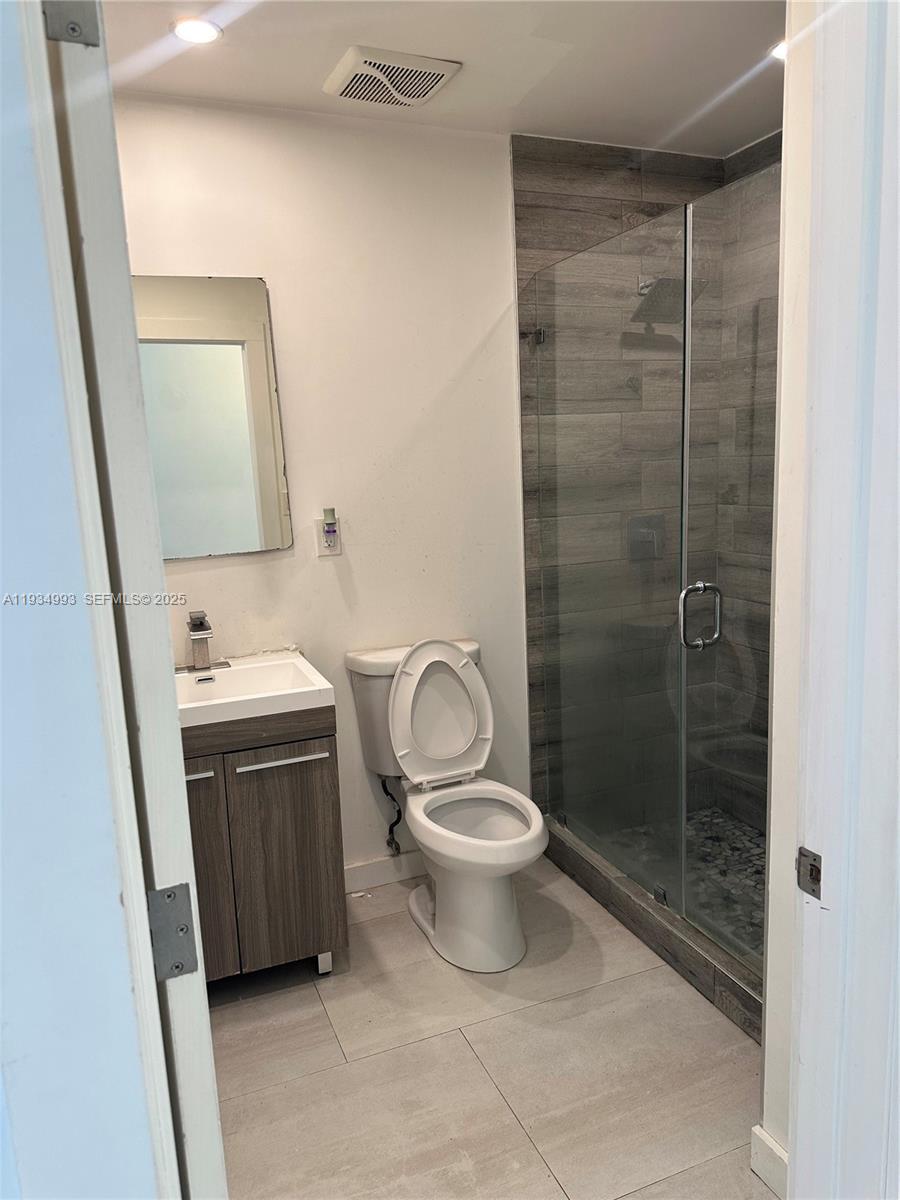 2832 Southwest 124th Court Miami, FL 33175 - Photo 21 of 30 a bathroom with a toilet a sink a mirror and vanity