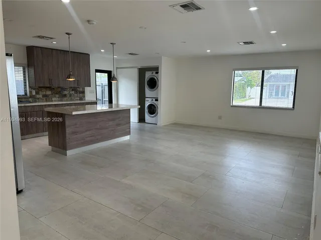 a large kitchen with a refrigerator and a stove top oven