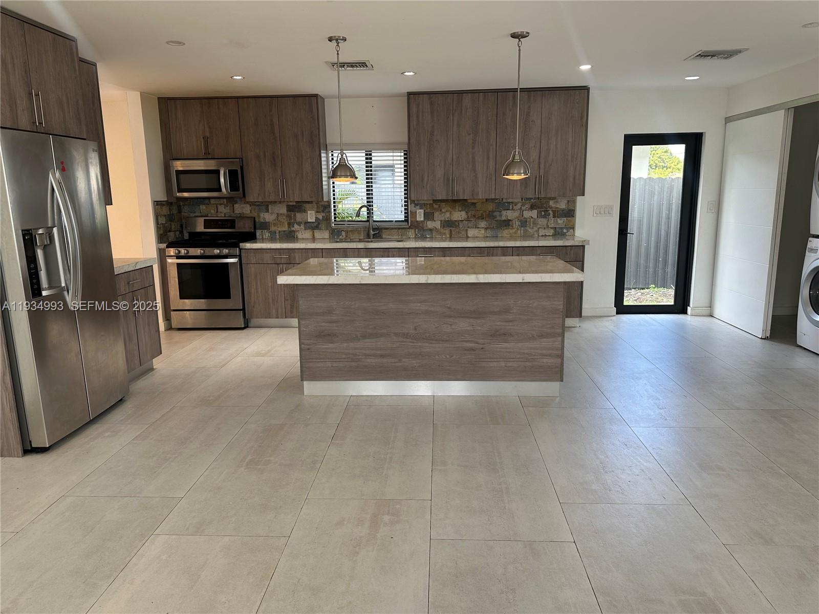 2832 Southwest 124th Court Miami, FL 33175 - Photo 5 of 30 a large kitchen with a refrigerator and a stove top oven