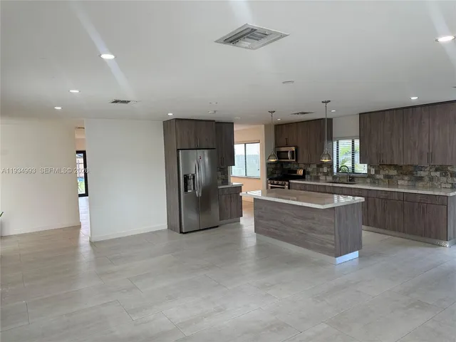 a large kitchen with cabinets and stainless steel appliances
