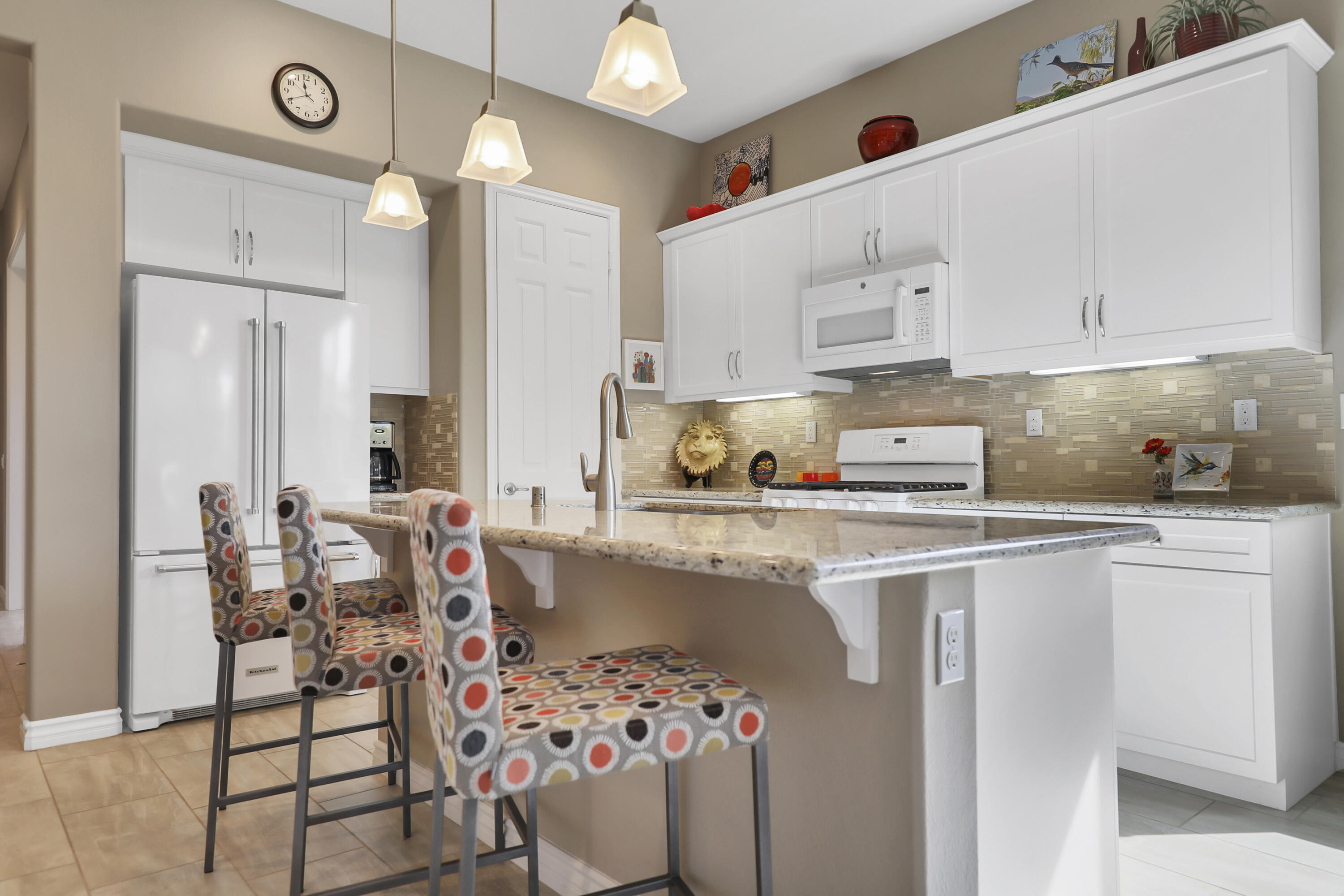 85685 Treviso Drive Indio, CA 92203 - Photo 11 of 32 a kitchen with a white cabinets and chairs