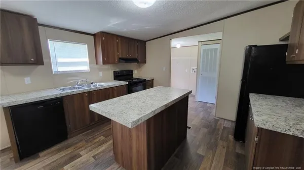 a kitchen with a sink a counter top space and stainless steel appliances