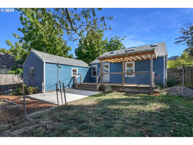 a backyard of a house with table and chairs