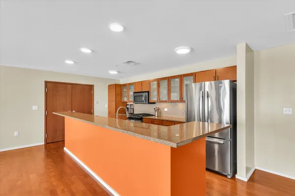 a large kitchen with stainless steel appliances granite countertop a refrigerator and a stove
