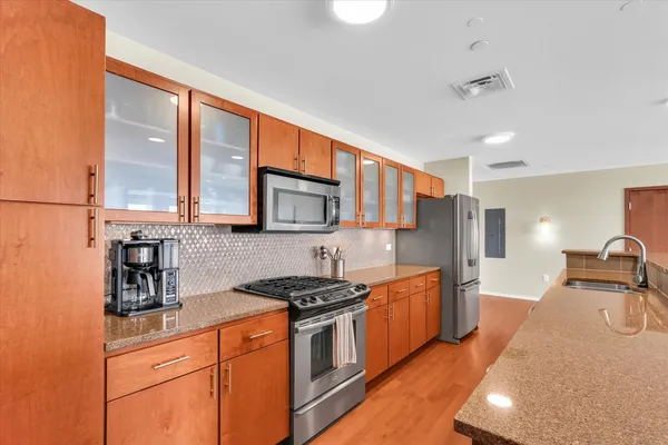 a kitchen with stainless steel appliances granite countertop a stove a sink and a refrigerator