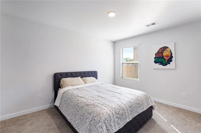 a bedroom with a bed and painting on the wall