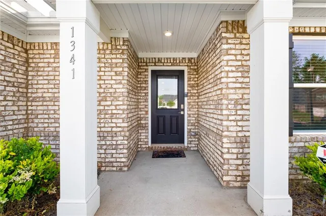 a view of front door of house with potted plants
