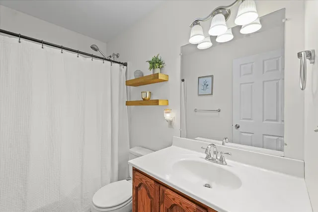 a bathroom with a sink vanity mirror and toilet