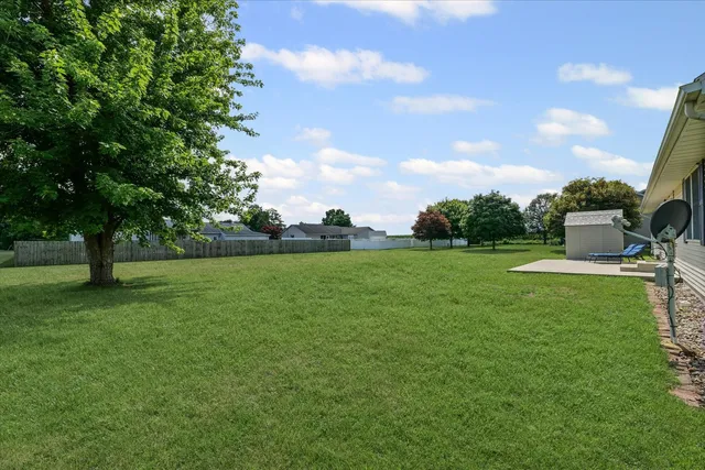 a view of a green field with trees in the background