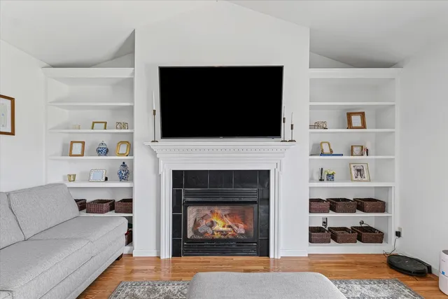 a living room with furniture a flat screen tv and a fireplace