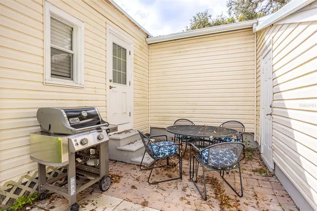 a view of a backyard with table and chairs and a large tree