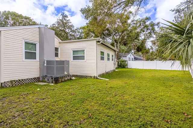 a view of a backyard with a house and large tree
