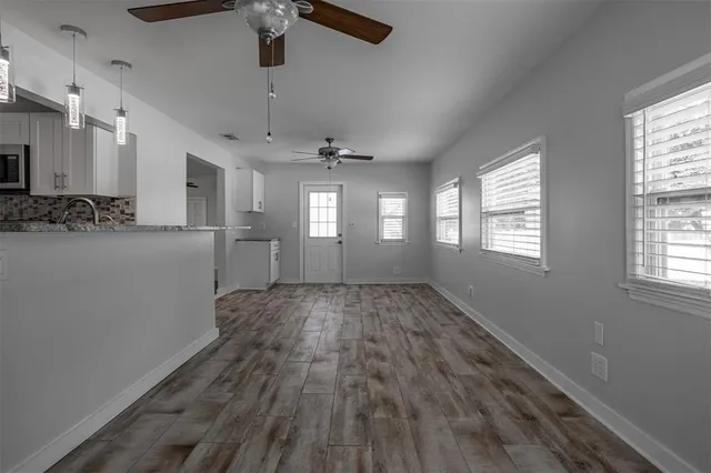 a view of empty room with wooden floor and window
