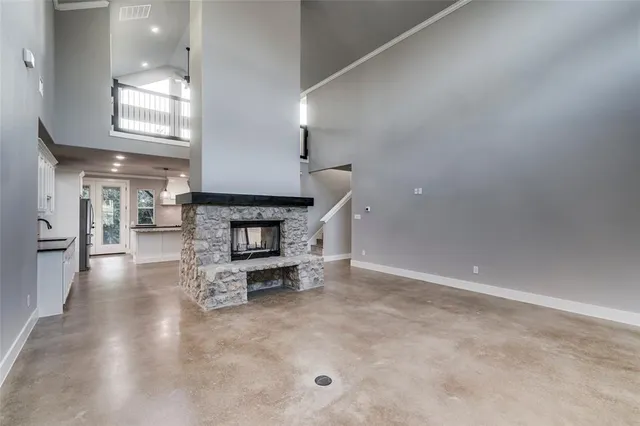 a view of an empty room with fire place and a window