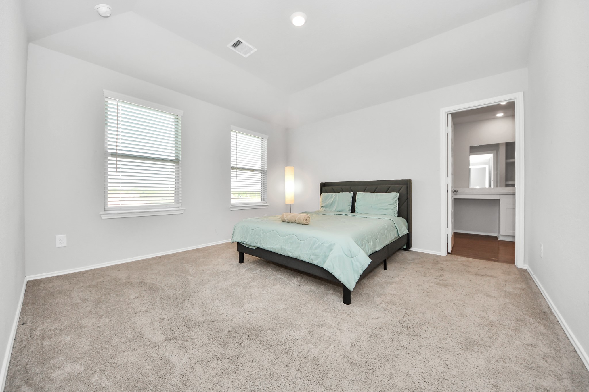 21738 Rustic River Ranch Avenue Waller, TX 77484 - Photo 11 of 24 Spacious and inviting bedroom featuring soft natural light, plush carpeting, and a clean, modern feel. Includes a private en-suite bath for added comfort and convenience.
