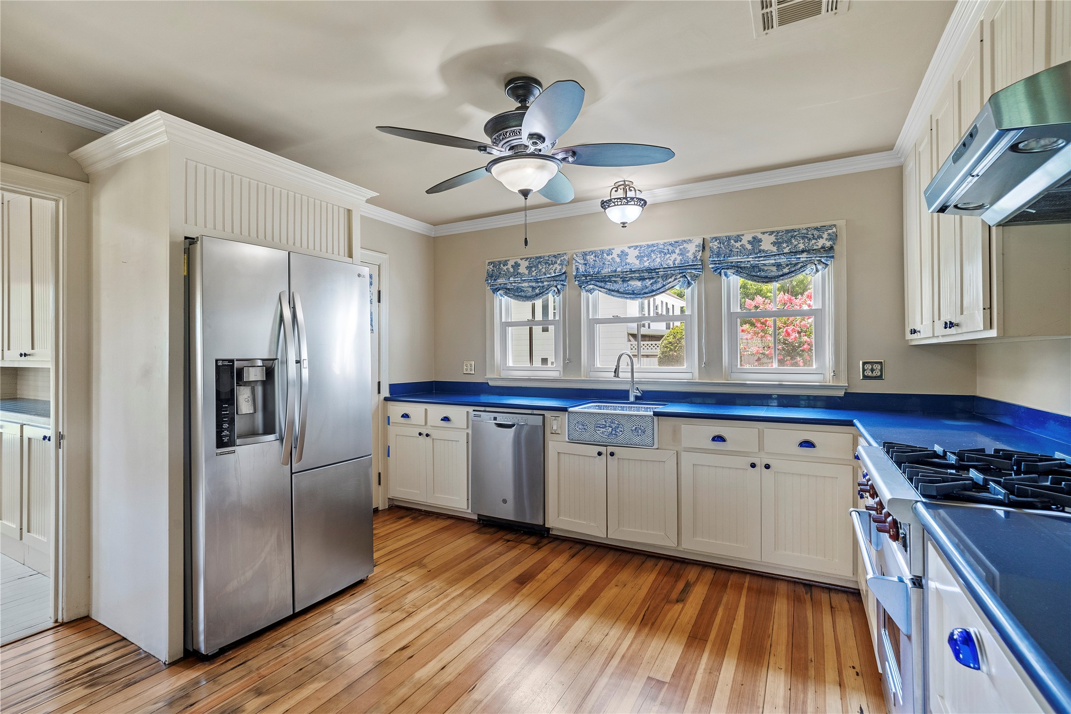 9827 FM 2759 Road Richmond, TX 77469 - Photo 21 of 50 a kitchen with granite countertop a refrigerator a sink dishwasher a stove and white cabinets with wooden floor