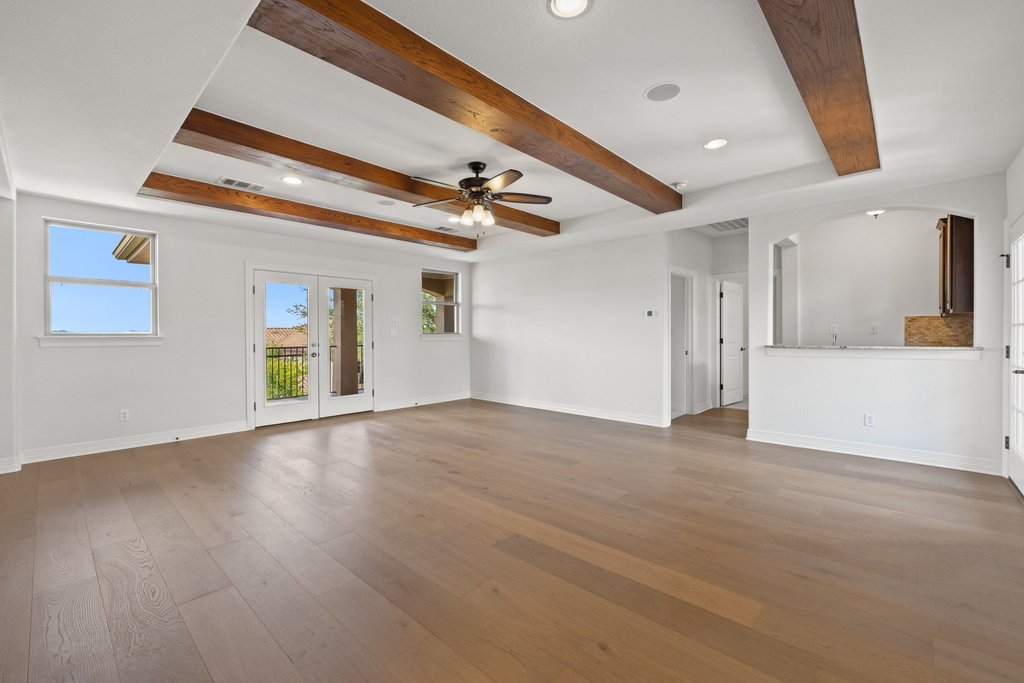 109 Largo Cove Austin, TX 78734 - Photo 21 of 40 Exposed wood beams and rich hardwood flooring define this generous, open living space.
