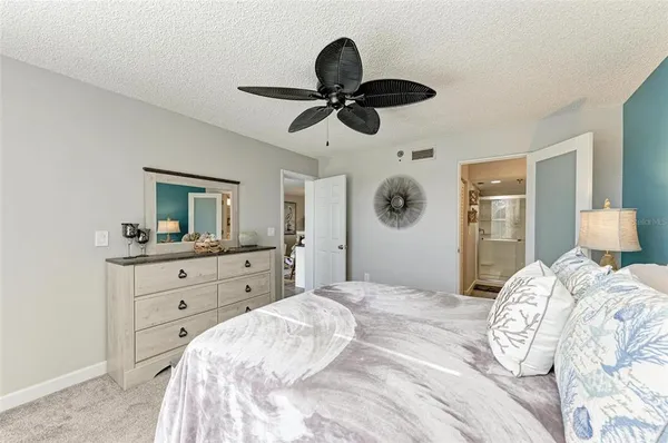 a bedroom with a bed and a chandelier fan