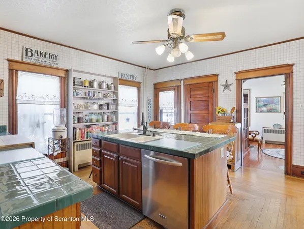 a view of a kitchen counter top space with wooden floor and stainless steel appliances