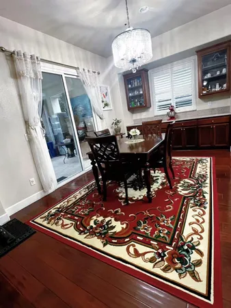 a view of a dining room with furniture a rug and wooden floor