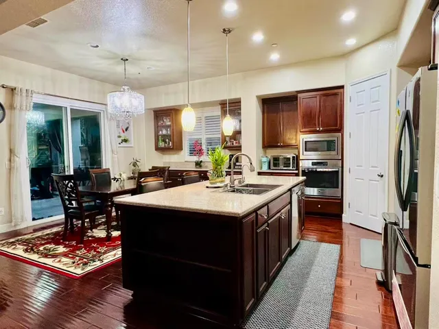 a kitchen with stainless steel appliances granite countertop a sink stove and refrigerator