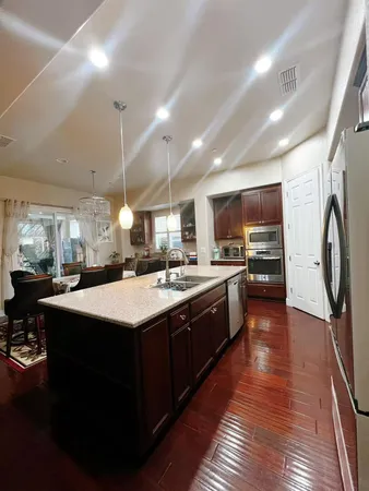 a kitchen with kitchen island granite countertop a sink appliances and cabinets
