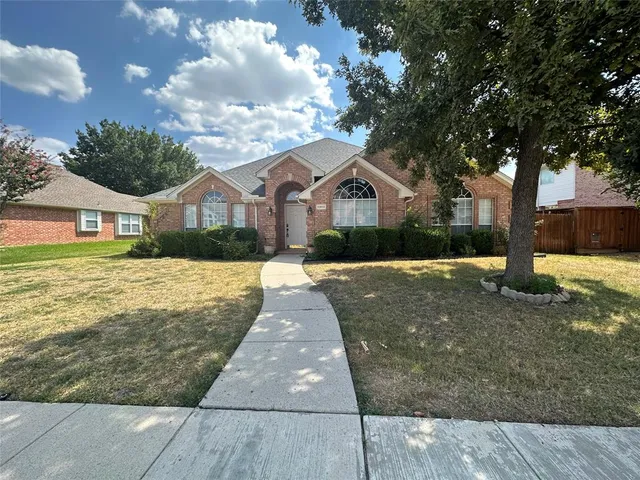 a front view of a house with a yard and trees