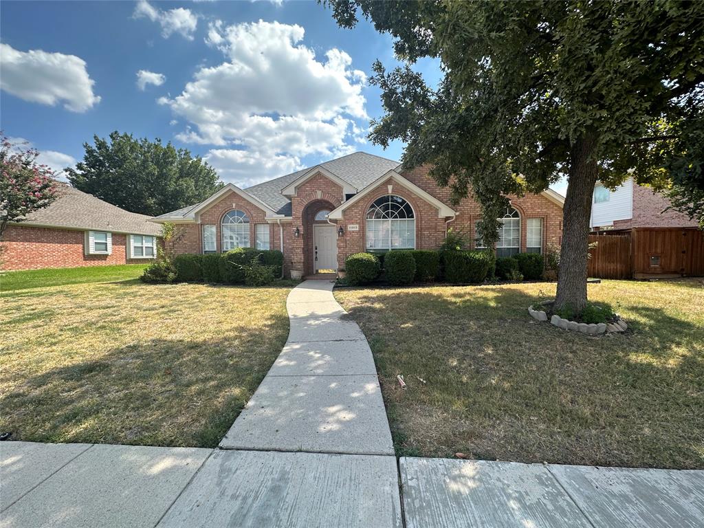 a front view of a house with a yard and trees