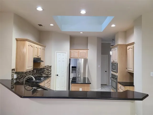 a kitchen with stainless steel appliances granite countertop a stove a sink and a refrigerator