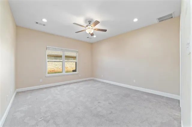 an empty room with windows and fan