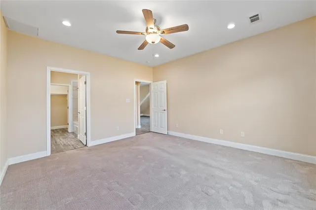 an empty room with closet and ceiling fan