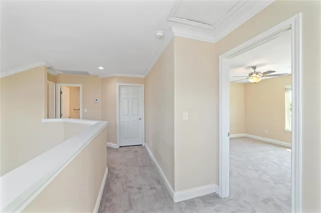 a view of a hallway to an empty room and wooden shelves