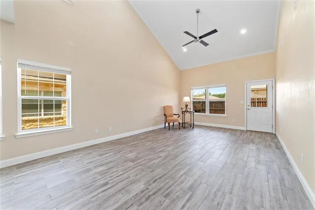 a view of a livingroom with wooden floor and a ceiling fan